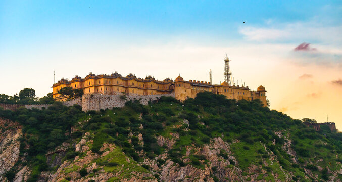 Majestic evening view of the historic Nahargarh Fort perched on the Aravali Hills overlooking Jaipur, India, during a beautiful sunset.